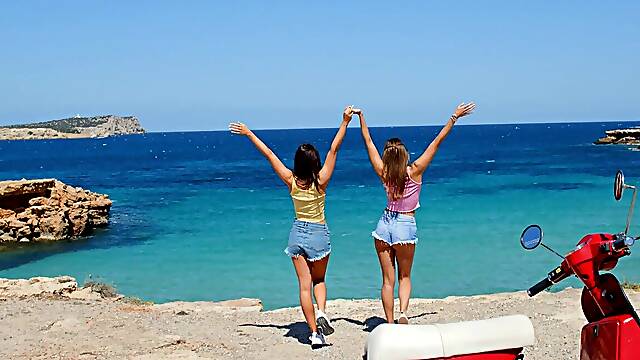 Two hot girls have fun on the beach with their bikinis on