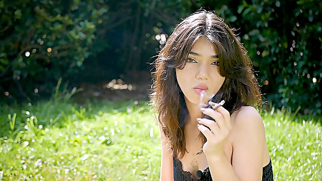 Arina Is Smoking One Black Cigarette Outdoors